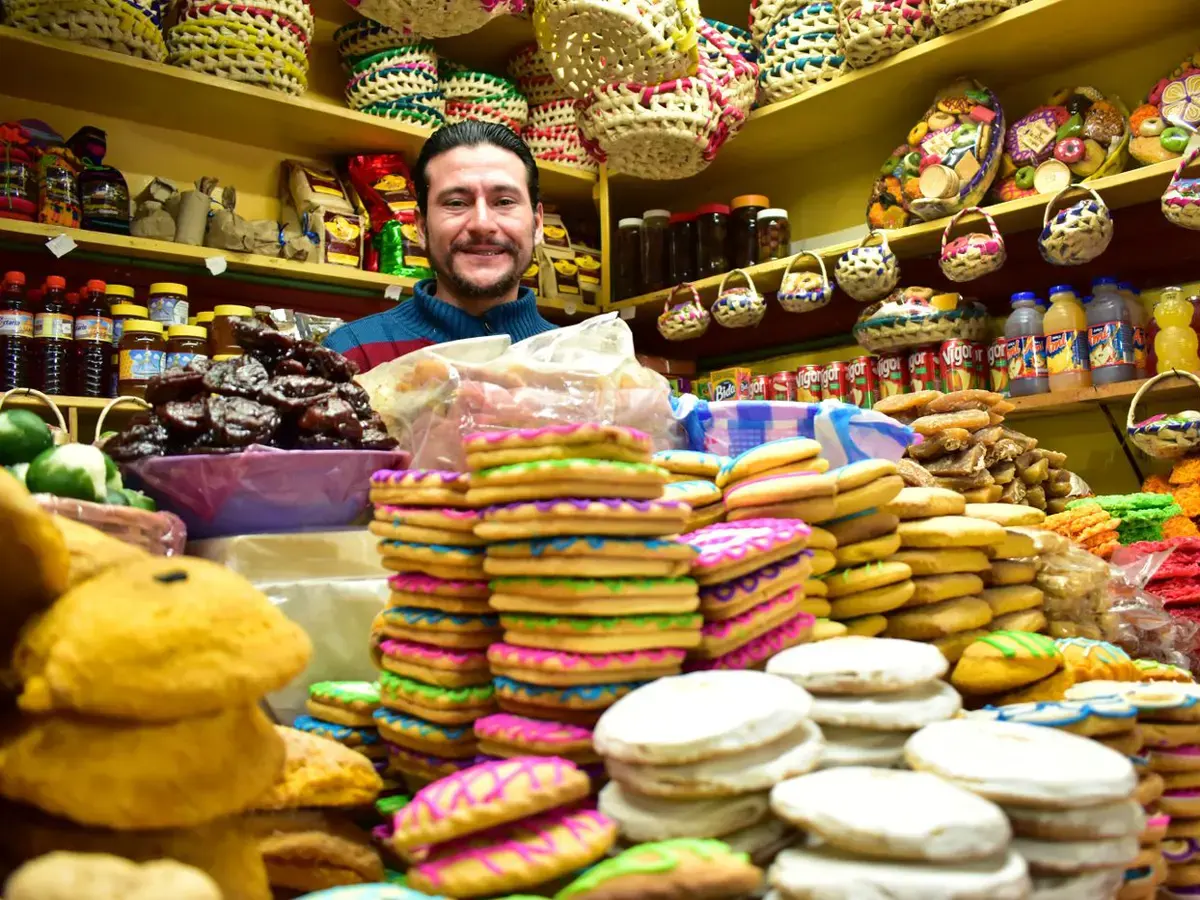Señor sonriendo en su tienda de dulces típicos